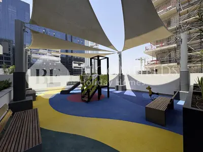 a playground in the middle of a building with benches at Bloomfeilds Comfortable STU Azizi Rivera in Dubai
