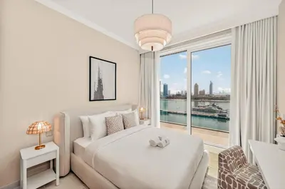 a white bedroom with a bed and a large window at Luxury 2BR Retreat Gorgeous Beach & Skyline Views in Dubai