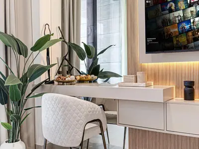 a white desk with a chair and a plant at Livin' Holidays - Studio - Bay View with Jacuzzi in Dubai