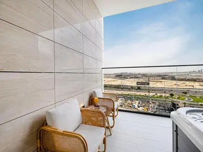 a balcony with chairs and a view of a race track at Livin' Holidays - Studio - Bay View with Jacuzzi in Dubai