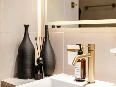 a bathroom sink with two black vases and a faucet at Livin' Holidays - Studio - Bay View with Jacuzzi in Dubai