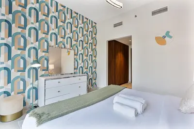 a bedroom with a bed with a blue and white patterned wall at Radiant - 3BR - JVC - near Sports City & Autodrome in Dubai