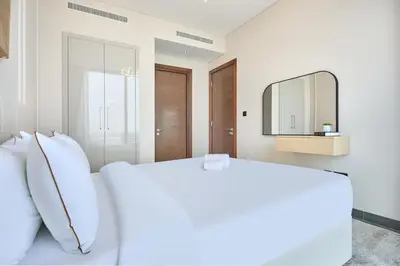 a bedroom with a white bed and a mirror at STAY BY LATINEM Luxury 1BR Holiday Home CB 0919 Near Burj Khalifa in Dubai