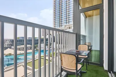 a balcony with a table and chairs and a pool at STAY BY LATINEM Luxury 1BR Holiday Home CB 0919 Near Burj Khalifa in Dubai