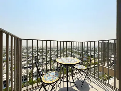 a table and chairs on a balcony with a view at 1BR in Collective With Pool, Gym and CoWorking Space in Dubai