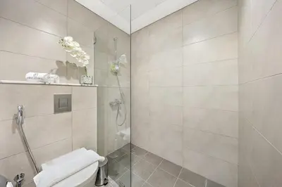 a bathroom with a toilet and a glass shower at Chic Studio in Dubai with Pool View Retreat Near Business Bay & Jumeirah Beach in Dubai