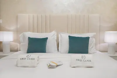 a white bed with two first class pillows on it at Chic Studio in Dubai with Pool View Retreat Near Business Bay & Jumeirah Beach in Dubai