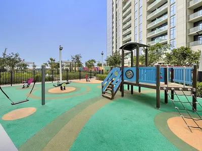 a playground with a slide and swings at Chic Studio in Dubai with Pool View Retreat Near Business Bay & Jumeirah Beach in Dubai