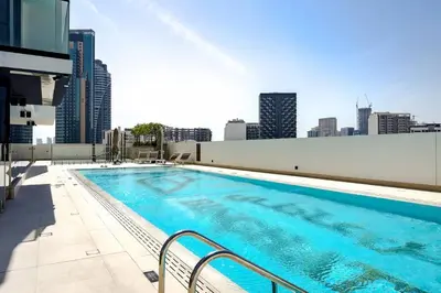 a large swimming pool on the roof of a building at Stylish 2BR JVC with Pool, Gym Access, and City Skyline Views in Dubai