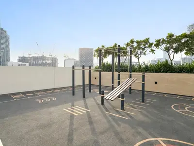 a bench in a parking lot with a view of a city at Stylish 2BR JVC with Pool, Gym Access, and City Skyline Views in Dubai