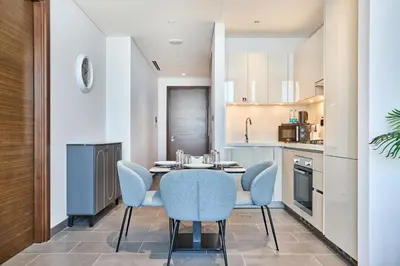 a kitchen and dining room with a table and chairs at STAY BY LATINEM Luxury 1BR Holiday Home CB 3015 Near Burj Khalifa in Dubai