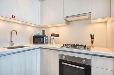 a kitchen with a sink and a stove top oven at STAY BY LATINEM Luxury 1BR Holiday Home CB 3015 Near Burj Khalifa in Dubai