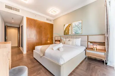 a bedroom with a large white bed and wooden floors at Apartment near Burj Khalifa and Dubai Mall, Central Location, Minutes to Dubai Marina and Palm Jumeirah - 8 BLVD Walk, Downtown Dubai by Deluxe Holiday Homes in Dubai