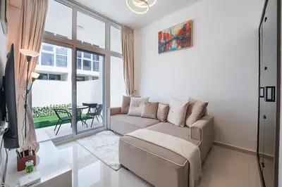 a living room with a couch and a large window at EasyGo Spacious 3BR with Garden in DAMAC Hills 2 in ‘Ūd al Bayḑāʼ