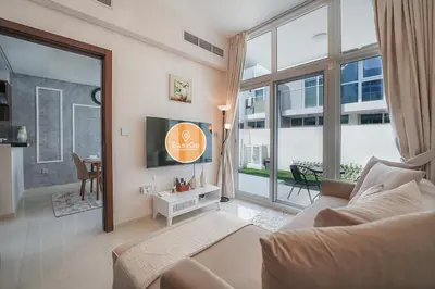 a living room with a couch and a large window at EasyGo Spacious 3BR with Garden in DAMAC Hills 2 in ‘Ūd al Bayḑāʼ