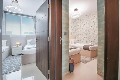 a room with two beds and a bedroom with two beds at EasyGo Spacious 3BR with Garden in DAMAC Hills 2 in ‘Ūd al Bayḑāʼ