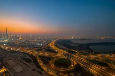 a busy freeway with a city in the background at night at FIRST CLASS 4BR Sobha Skyline Luxury in Dubai