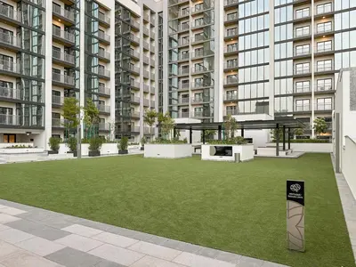 a courtyard in an apartment building with a green lawn at FIRST CLASS 4BR Sobha Skyline Luxury in Dubai