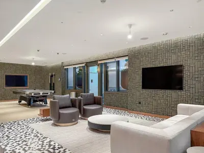 a living room with a tv on a brick wall at FIRST CLASS 4BR Sobha Skyline Luxury in Dubai