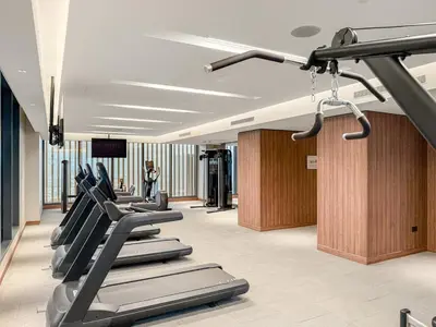 a gym with treadmills and a row of exercise bikes at FIRST CLASS 4BR Sobha Skyline Luxury in Dubai