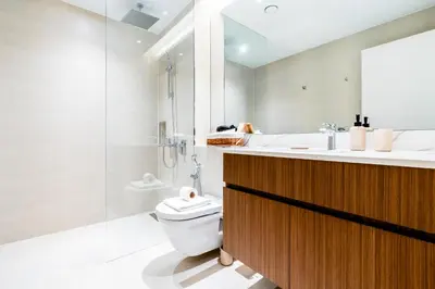 a white bathroom with a sink and a toilet at Stylish Apartment in La Mer Dubai in Dubai