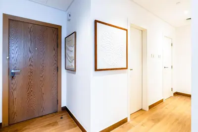 a hallway with a door and a picture on a wall at Stylish Apartment in La Mer Dubai in Dubai