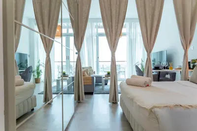 a bedroom with a bed and a living room at Scent of the Palms by Lagom in Dubai