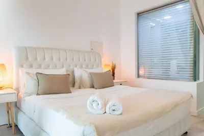 a bedroom with a large white bed with towels on it at Scent of the Palms by Lagom in Dubai
