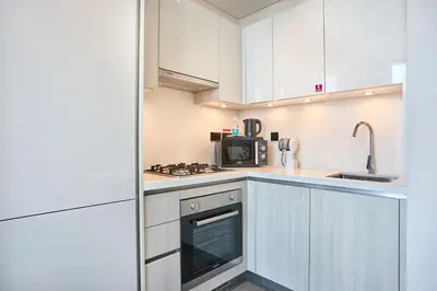 a kitchen with white cabinets and a microwave at STAY BY LATINEM Luxury 1BR Holiday Home CB 1409 Near Burj Khalifa in Dubai