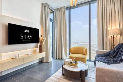 a living room with a tv and a couch and a chair at STAY BY LATINEM Luxury 1BR Holiday Home CB 1409 Near Burj Khalifa in Dubai