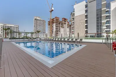 a swimming pool with chairs and buildings in the background at Chic Dubai Retreat at Azizi Riviera 65 in Dubai