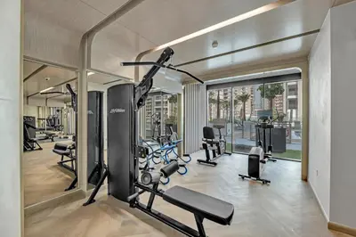 a gym with several treadmills and elliptical machines at Chic Dubai Retreat at Azizi Riviera 65 in Dubai