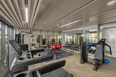 a gym with treadmills and machines in a room at Chic Dubai Retreat at Azizi Riviera 65 in Dubai