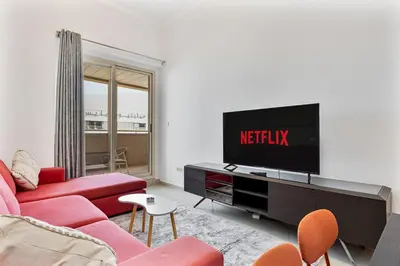 a living room with a red couch and a tv at Retro 1BR APT in Marina Near JBR Beach & Mall in Dubai