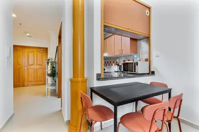 a kitchen with a black table and orange chairs at Retro 1BR APT in Marina Near JBR Beach & Mall in Dubai