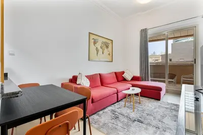 a living room with a red couch and a table at Retro 1BR APT in Marina Near JBR Beach & Mall in Dubai