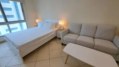 a bedroom with a bed and a couch at DRUVYA HOLIDAY HOMES, Marina Diamond 1, Close to Sobha Realty Metro 3 min walkable in Dubai