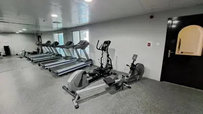 a gym with several tread machines in a room at DRUVYA HOLIDAY HOMES, Marina Diamond 1, Close to Sobha Realty Metro 3 min walkable in Dubai