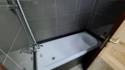 a bath tub in a bathroom with a tile wall at DRUVYA HOLIDAY HOMES, Marina Diamond 1, Close to Sobha Realty Metro 3 min walkable in Dubai