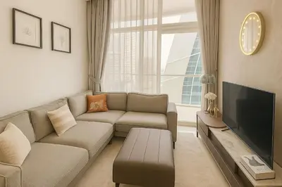 a living room with a couch and a flat screen tv at Cosy 2BR Business Bay with Canal view and Swimming pool in Dubai