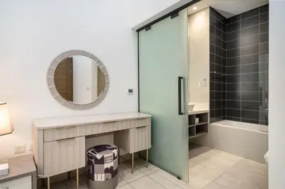 a bathroom with a shower and a sink and a mirror at Luxury JVC 1BR plus Maids Room Escape with Terrace in Dubai