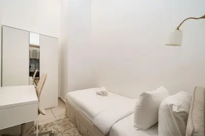 a white room with a bed and a desk and a lamp at Luxury JVC 1BR plus Maids Room Escape with Terrace in Dubai