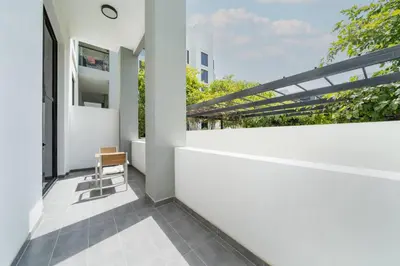 a balcony with a white wall and a chair at Luxury JVC 1BR plus Maids Room Escape with Terrace in Dubai