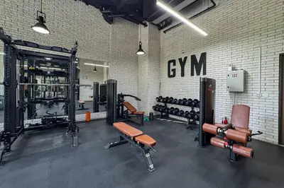 a gym with dumbbells and equipment in a brick wall at Luxury JVC 1BR plus Maids Room Escape with Terrace in Dubai