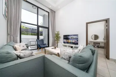 a living room with a couch and a tv at Luxury JVC 1BR plus Maids Room Escape with Terrace in Dubai