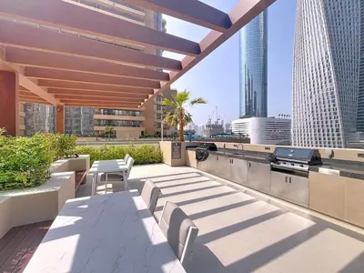 a rooftop patio with a table and chairs on a building at Vacationer l Urban Luxe 1 Bedroom l with Marina Views in Dubai