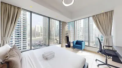 a bedroom with a white bed and large windows at Vacationer l Bright 1 Bedroom l near Marina Promenade in Dubai