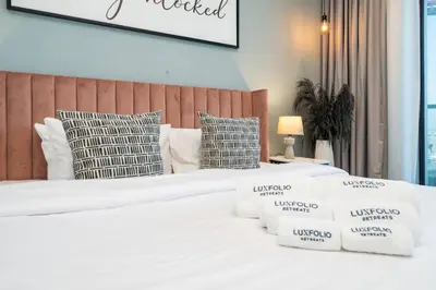 a bedroom with two beds with white sheets and pillows at Contemporary Business Bay 1-Bed with City Views in Dubai