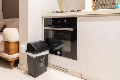 a black oven in a kitchen with a trash can at Stylish 1 BHK in Damac Zada Tower, Business Bay in Dubai