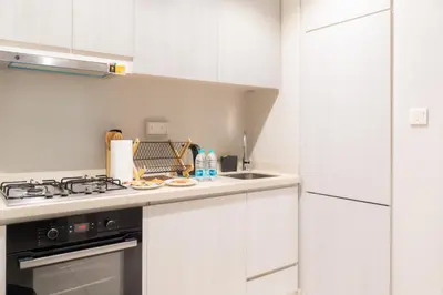 a white kitchen with a stove and a sink at Stylish 1 BHK in Damac Zada Tower, Business Bay in Dubai